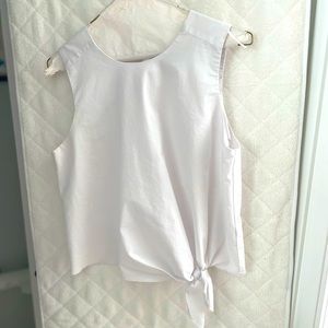 White sleeveless top with side tie on bottom.